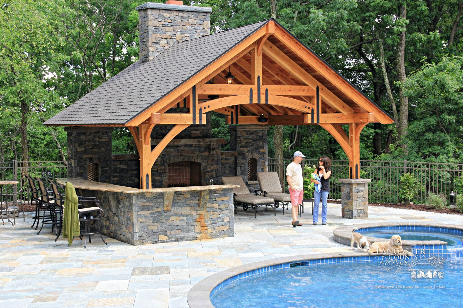 grand teton timber frame pavilion sitting poolside on a large patio
